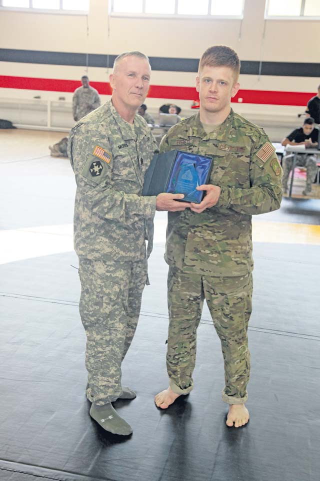 Army Sgt. Maj. James Murrin, senior enlisted leader of the 7th Civil Support Command, presents the cruiserweight trophy to Air Force Staff Sgt. Joseph B. Everett of the 86th Aircraft Maintenance Squadron, during the 7th Civil Support Command's Inaugural Combatives Tournament Aug. 14.
