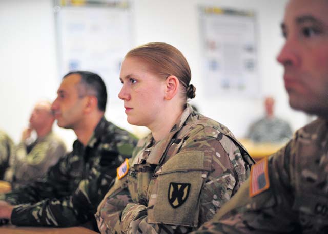 Capt. Karen M. Berggren, the operational law judge advocate for the 18th Multi-National Brigade, listens to an update briefing during Rapid Trident 15 July 30 at the International Peacekeeping and Security Center.