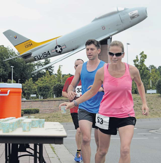 Participants of the Ramstein Half Marathon grab cups of water at the 6 mile mark of the 13.1 mile course Aug. 15 on Ramstein. First, second and third place prizes were awarded to the top male and female times in four age groups, as well as prizes for the top male and female time overall.