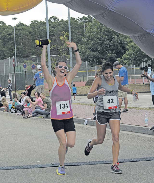 Two participants of the Ramstein Half Marathon cross the finish line Aug. 15 on Ramstein.