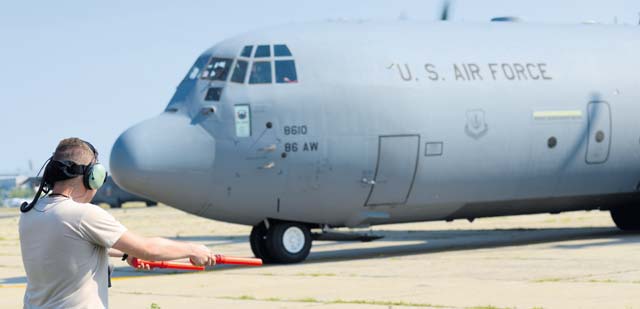 Airman 1st Class Zachary Hitchcock, 37th Airlift Squadron crew chief, marshalls an 86th Airlift Wing C-130J Super Hercules away from its parking spot Aug. 16 at Otopeni Air Base, Romania.