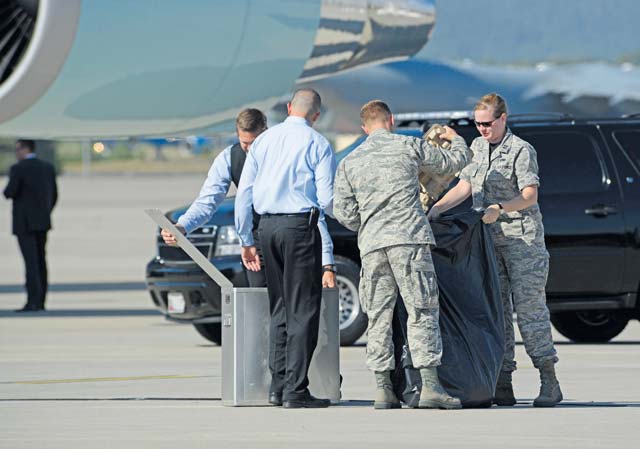 Capt. Teresa Crampton, 721st Aerial Port Squadron air freight flight commander, and 2nd Lt. Denver Barrows, 721st APS ramp services officer in charge, gather trash from Air Force One flight attendants July 24 on Ramstein. President Obama was traveling to Africa and stopped on Ramstein to refuel.