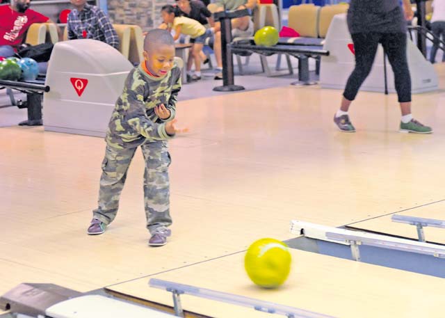 A child from the 21st Theater Sustainment Command’s Special Troops Battalion throws a bowling ball down the lane during STB’s back-to-school bowl-a-thon at the Ramstein Bowling Center Aug. 24.