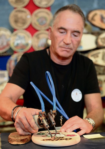 Martin Reimlinger engraves a piece of wood Sept. 19 on Ramstein. Reimlinger was one of many vendors present at the 51st Ramstein Bazaar to showcase his merchandise.