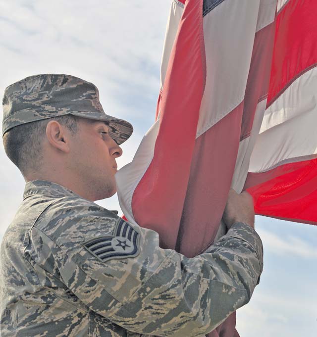 Staff Sgt. Casey Chillemi, 86th Munitions Squadron munitions systems specialist, catches the U.S. flag as it’s lowered during the 9/11 retreat ceremony Sept. 11 on Ramstein. The ceremony paid tribute to the nearly 3,000 lives lost 14 years ago, including the first responders who made the ultimate sacrifice helping those escape the collapsing World Trade Center towers.