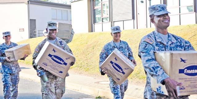 (Left to right) Staff Sgt. Jessica Gregor, Sgt. 1st Class Marcus Mitchell, Sgt. Maj. Michael Ledesma and Master Sgt. Addley Saimbert, all members of the Rheinland-Pfalz chapter of the Sergeant Morales Club and NCOs assigned to the 21st Theater Sustainment Command, move boxes and furniture at Sembach Middle and Elementary Schools Aug. 26. The first official day of school for the Department of Defense Education Activity students was Aug. 31.
