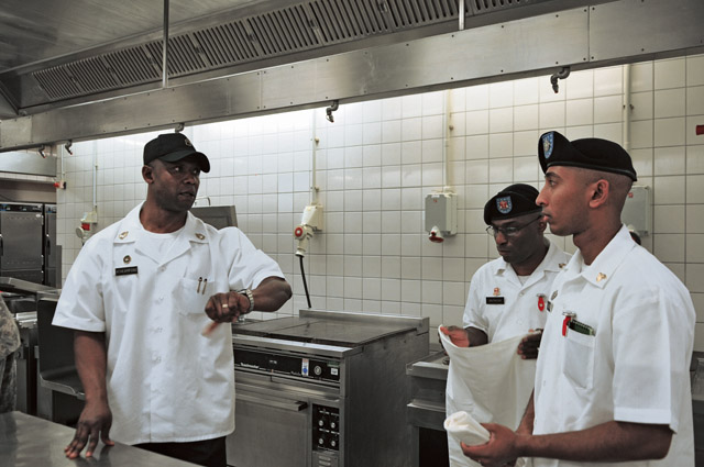 Sgt. 1st Class Ulysses Acheampong, 66th Transportation Company 21st Theater Sustainment Command and one of the judges of the 21st TSC Culinary Warrior of the Year, discusses timing with some participants during the competition held Sept. 2 on Kleber Kaserne.