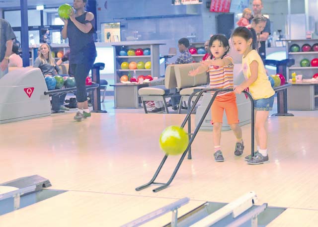 Children from the 21st Theater Sustainment Command’s Special Troops Battalion throw a bowling ball down the lane during STB’s back-to-school bowl-a-thon at the Ramstein Bowling Center Aug. 24.