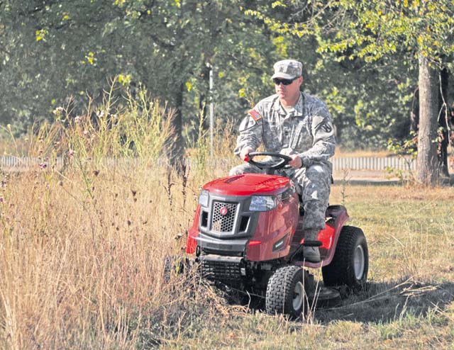First Sgt. Ryan Sattelberg, a member of the Rheinland-Pfalz chapter of the Sergeant Morales Club, tackles the tall, 2-foot wild weeds growing directly in front of Sembach Elementary School.