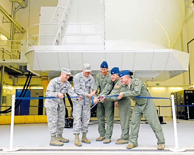 Brig. Gen. Jon T. Thomas, 86th Airlift Wing commander (second from left),  Col. Eric Mayheu, Air Mobility Command Aircrew Operations and Training Division chief (right), and other 86th AW members cut a ribbon during the opening ceremony of the C-130J Super Hercules Flight Simulator Aug. 24 on Ramstein.