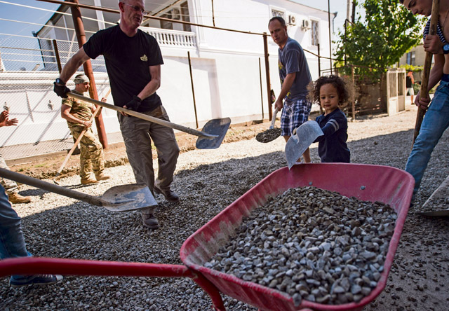 Students, teachers, neighbors and U.S. Air Force and Georgian army engineers pitch in to help spread gravel for Gori Public School No. 4’s new driveway Aug. 30 in Gori, Georgia. The new driveway and entire renovation of the school is part of a Humanitarian and Civic Assistance project, a U.S. European Command program that is designed to provide assistance to the Georgian populace and help military members and civilians hone building and construction skills and trades. Humanitarian and Civic Assistance projects enhance operational readiness of military personnel while providing support to the host nation's population. For more photos, see Page 8.