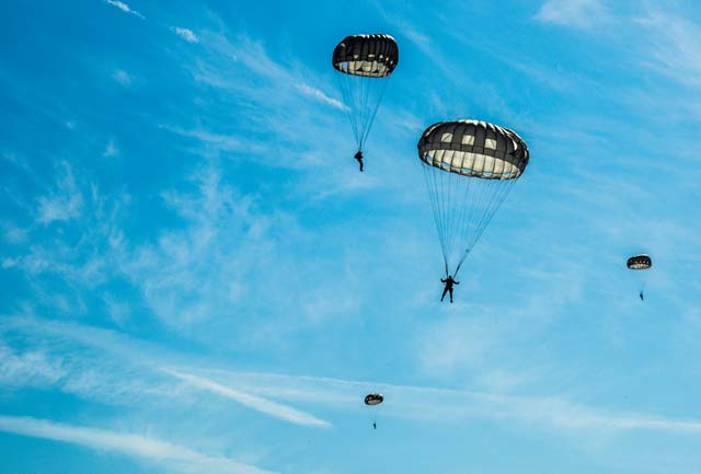 Airmen and Soldiers parachute from an 86th Airlift Wing C-130J Super Hercules over Alzey drop zone Aug. 31 in Germany. More than 20 Air Force independent duty medical technicians, security forces members and Army Special Forces paratroopers descended to the ground to quickly respond to a simulated medical emergency.