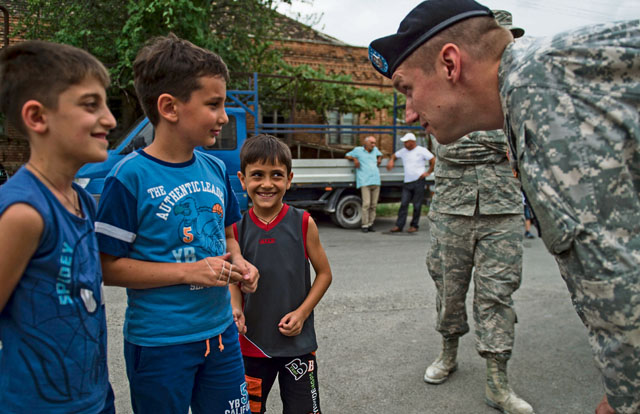 U.S. Army Sgt. Williams Thompson, U.S. Army Europe Civil Affairs specialist from the 457th Civil Affairs Battalion, talks to students during the opening ceremony of Public School No. 4 Aug. 28 in Gori, Georgia. 