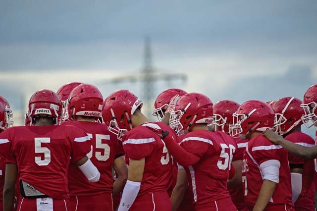 Members of the Kaiserslautern Raiders huddle together before their game Sept. 25 on Vogelweh. Prior to the game, Kaiserslautern High School held a ceremony to recognize its senior athletes, which included 11 of its football players.