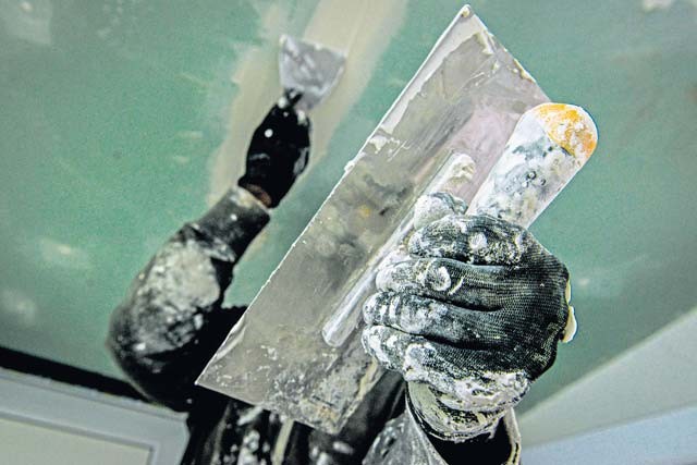 Staff Sgt. Altes Durand, 435th Construction and Training Squadron NCOIC of heating, cooling, ventilation and air conditioning, applies spackle paste to a ceiling Oct. 18 at Liceul Teoretic Alexei Mateevici School in Sanatauca, Moldova.