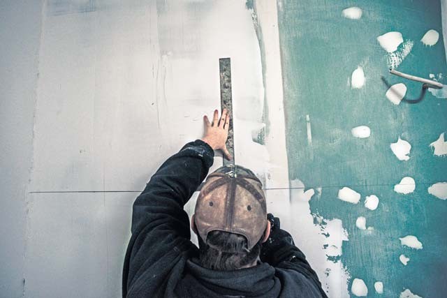 Senior Airman Bradley Cain, 435th Construction and Training Squadron structural craftsman, marks a wall as part of renovations to a locker room Oct. 18 at Liceul Teoretic Alexei Mateevici School in Sanatauca, Moldova.