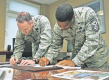Brig. Gen. Jon T. Thomas, 86th Airlift Wing commander, and Chief Master Sgt. Phillip Easton, 86th AW command chief, sign pledge forms in support of the Combined Federal Campaign-Overseas Oct. 22 on Ramstein. The CFC-O allows U.S. military members and U.S. government civilian employees to donate to the charity of their choice, with more than 2,600 charities available to choose from.
