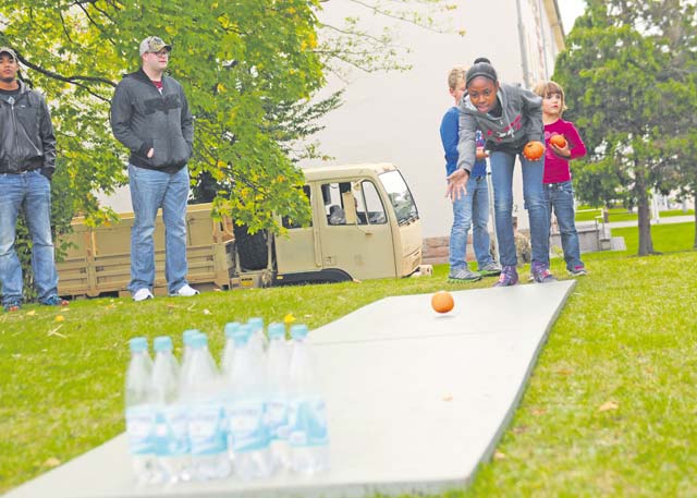 Children of Soldiers assigned to the 21st Theater Sustainment Command’s Special Troops Battalion attempt to knock over bottles using pumpkins during a STB Fall Festival Sept. 26 on Daenner Kaserne.