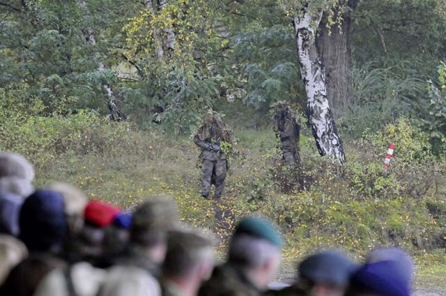German army snipers reveal themselves from a hide position before stands filled with on-lookers at the distinguished visitor day of the German army’s Joint Demonstration Exercise Oct. 9 at the German army training area in Muenster.