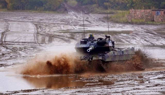 A German army Leopard tank conducts maneuvers during the distinguished visitor day of the German army’s Joint Demonstration Exercise Oct. 9 at the German army training area in Muenster. On this tank, the gun tube is marked in white and the targeting system in yellow for demonstration purposes.