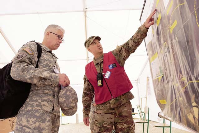 Brig. Gen. Arlan M. DeBlieck (left), commanding general, 7th Civil Support Command, listens to a briefing from Lt. Col. Jason Welch, the executive officer for the 2500th Digital Liaison Detachment, 7th CSC, during NATO consequence management exercise Ukraine 2015, Sept. 23.