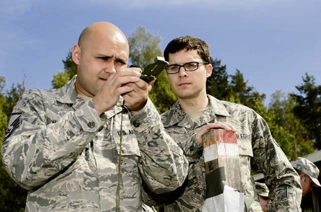 Master Sgt. Steven Hollatz (left), 7th Weather Squadron logistics and resources NCO in charge, and Staff Sgt. Cody Weakland, 7th WS battlefield weather Airman, ensure the accuracy of their compass during an annual training exercise known as Cadre Focus Sept. 16 at Grafenwoehr Training Area in Germany. Approximately 30 Airmen took part in Cadre Focus, an exercise designed to improve forecasting and Army skills such as land navigation and group movements.