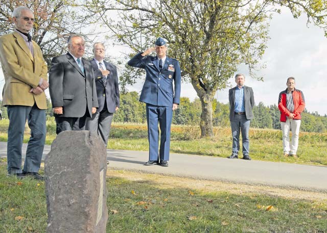 Col. Harry Benham, U.S. Air Forces in Europe Operations and Plans chief, salutes during the playing of taps during the unveiling of a memorial stone for a World War II pilot Sept. 25 in Dietingen, Germany. Second Lt. Priesley Cooper Jr. was conducting an escorting mission when he was shot down.