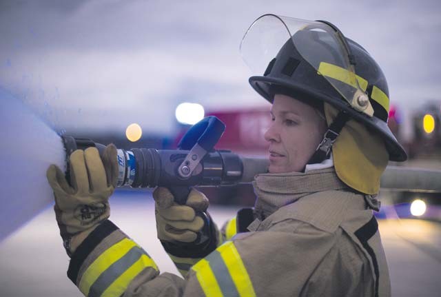 Col. Laura Johnson, 86th Civil Engineer Group commander, practices using a fire hose Oct. 8 on Ramstein. Leadership from throughout Ramstein helped 86th Civil Engineer Squadron firefighters demonstrate how they extinguish an aircraft fire as part of Fire Prevention Week.