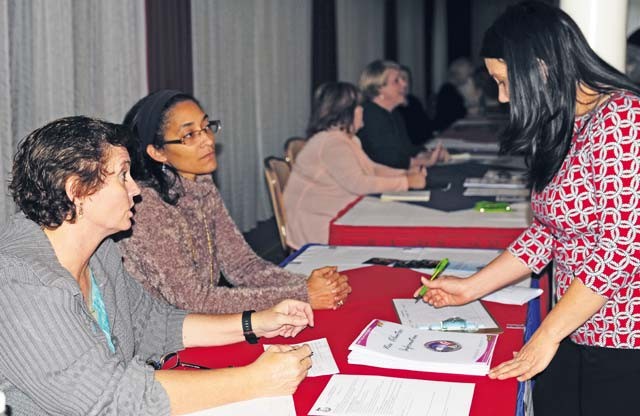 Photo by Ronna Anderson Schelby Kate Dunbar, focus group leader of AFAP Benefits and Entitlements (far left), helps gather issues and signs up volunteers at the Army Family Action Plan town hall event Oct. 22 at Armstrong's Club on Vogelweh.