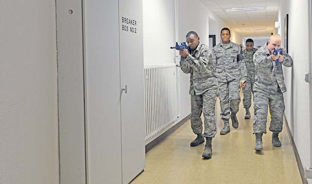 Two students from the Expeditionary Active Shooter Training class, followed by their instructors, search a hallway as they make their way to an exit during an active shooter scenario Nov. 5 on Ramstein. The EAST class is a requirement for deploying Airmen and includes hands-on practical training to further prepare the student for a real active shooter situation.