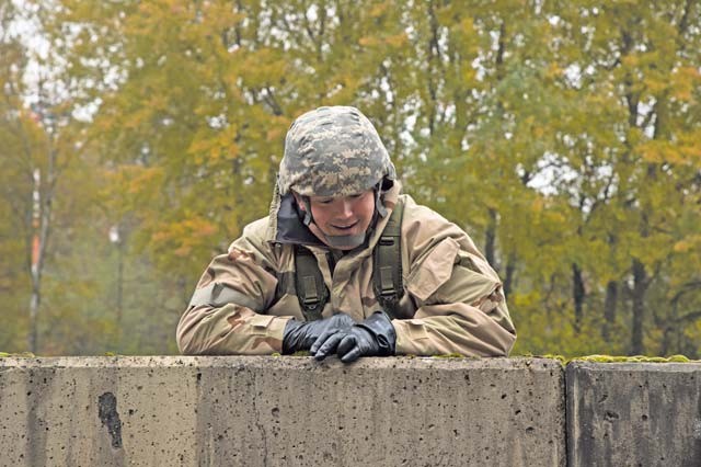 An explosive ordnance disposal ruck march participant climbs over a wall Oct. 30 on Ramstein.