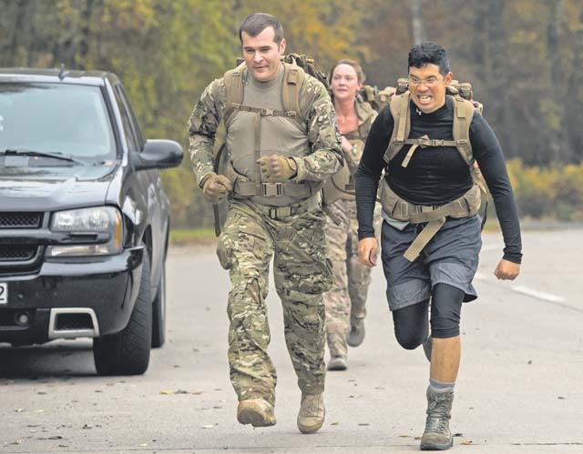 Staff Sgt. Michael Ferguson, 786th Civil Engineer Squadron explosive ordnance disposal technician (left), and Capt. Aristotle Rivera, 86th Airlift Wing chaplain, sprint to the finish line during a ruck march Oct. 30 on Ramstein.