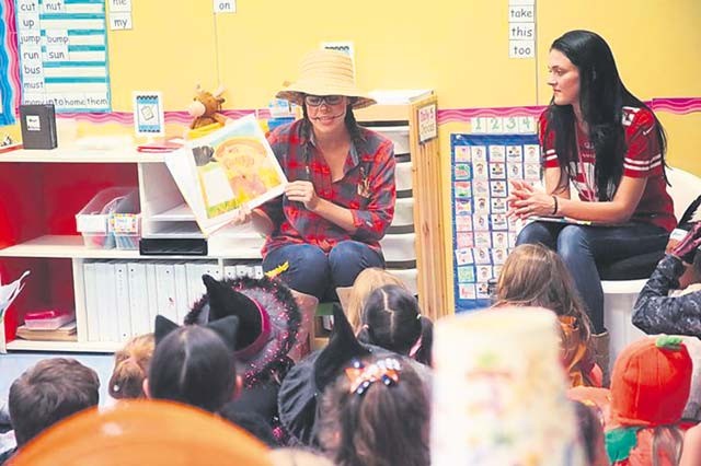Katherine Sadusky (left) and Kylie Nelson, both second-grade teachers, read books to students during a Fall Harvest Moon Reading night Oct. 27 at Vogelweh Elementary School. Students dressed in costumes, enjoyed a hot dog dinner and listened to books read to them by teacher volunteers. All students received a free book courtesy of VES PTSA.