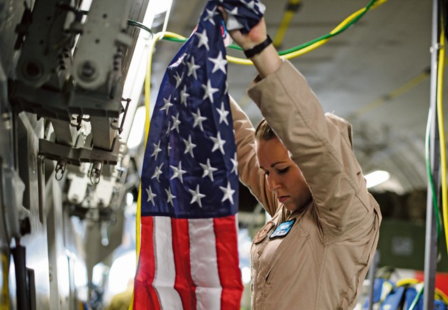 Senior Airman Beverly Spencer, 10th Expeditionary Aeromedical Evacuation Flight technician, hangs a flag inside a C-17 Globemaster III Nov. 10 on Ramstein. Spencer and crews from the 10th EAEF are deployed to Ramstein as a bridge between the deployed environment and medical facilities in the U.S. and Germany. Many Air Force aircraft conduct aeromedical evacuation, bringing the injured to the help they need.