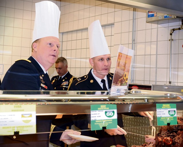 Maj. Gen. Duane A. Gamble (left) and Command Sgt. Maj. Rodney J. Rhoades, 21st TSC command team, work as a culinary duo to feed their Soldiers and family members during a Thanksgiving feast held Nov. 26 at the Clock Tower Cafe on Kleber Kaserne. The commanding general and senior enlisted leader pulled shifts on the serving line before sharing a Thanksgiving meal with the U.S. ambassador to Germany, their wives and families. Approximately 1,100 Soldiers, civilians and family members shared their Thanksgiving at the 21st TSC-operated Kleber Kaserne and Rhine Ordnance Barracks facilities in Kaiserslautern.