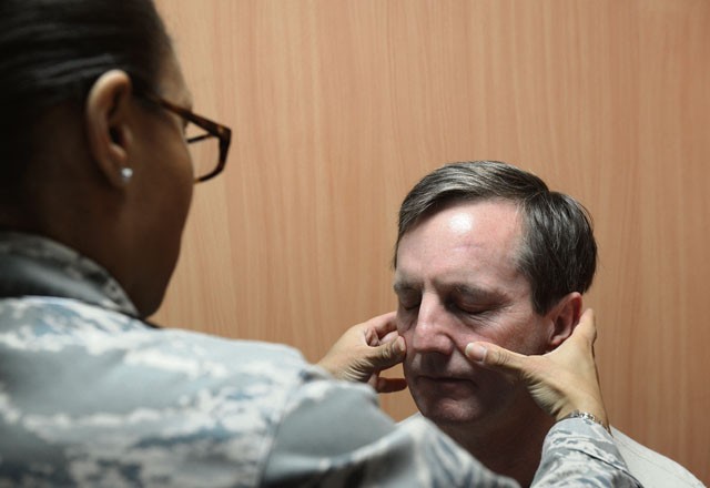 Maj. Courtney Wallace, Family Health Clinic clinical nurse, feels for signs of inflammation for Col. James Stephenson, 86th Medical Operations Squadron commander, at the Cold and Allergy Clinic Nov. 4 on Ramstein. Patients suffering from cough, congestion, runny nose, itchy eyes or other such symptoms can now be seen by a doctor much sooner than they had been able to prior to the opening of the new clinic.
