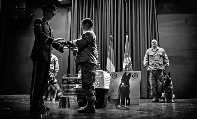 Staff Sgt. Michael Smith, 86th Security Forces Squadron military working dog handler, receives an American flag during a memorial service in honor of his MWD Brutus Nov. 20 on Ramstein. Brutus served with the 86th SFS as a patrol explosive detection dog, where he deployed three times in support of operations Iraqi Freedom and Enduring Freedom. 