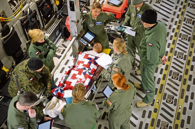 Members of the 86th Aeromedical Evacuation Squadron and Polish aeromedical evacuation specialists discuss the proper treatment of a mock patient Dec. 3 on Ramstein. Members of the 86th AES showcased their skills for the Polish medical officials in order for them to adapt desired skills. 