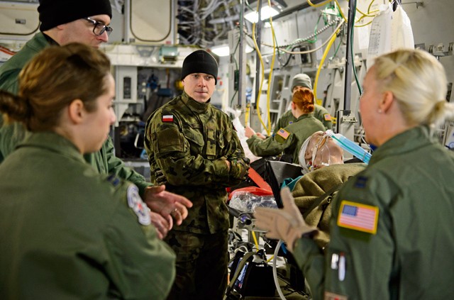Polish air force 2nd Lt. Andrzej Nartonowicz, aeromedical evacuation doctor (center), listens as members of the 86th Aeromedical Evacuation Squadron and Ramstein’s Critical Care Air Transport Team speak with Polish aeromedical evacuation doctors Dec. 3 on Ramstein. Ramstein’s aeromedical evacuation teams shared knowledge and skills with the Polish aeromedical evacuation team touring Ramstein. 