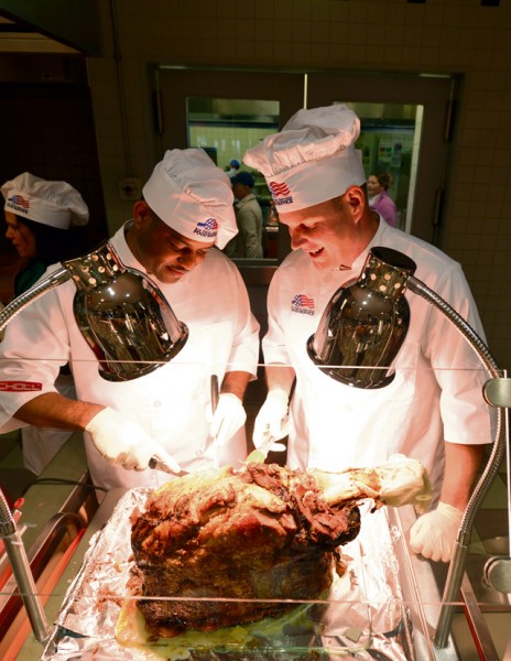 Brig. Gen. Jon T. Thomas, 86th Airlift Wing commander (right), and Chief Master Sgt. Phillip L. Easton, 86th Airlift Wing command chief, carve a beef roast during Thanksgiving meals Nov. 26 at the Rheinland Inn Dining Facility on Ramstein. The event was open to all Department of Defense ID card holders, retirees and family members. Senior leaders serving meals on Thanksgiving to service members and their families has been a longstanding tradition and a great opportunity to spend time with service members during the holiday.