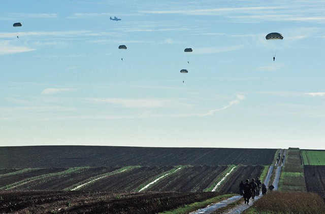 Photo by Airman 1st Class Larissa Greatwood Airmen, Soldiers, NATO members and Santa Claus parachute onto a landing zone during an International Jump Week Toy Drop event Dec. 7 at Alzey Drop Zone, Germany. International Jump Week is an event that gives NATO members the opportunity to work together and build camaraderie and partnerships.
