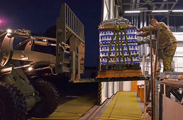 Photo by Airman 1st Class Tryphena Mayhugh Army 5th Quartermaster Detachment Soldiers load a pallet of toys onto a forklift for an International Jump Week Toy Drop event Dec. 7 on Ramstein. The pallet was loaded onto an 86th Airlift Wing C-130J Super Hercules and dropped at Alzey Drop Zone, Germany.