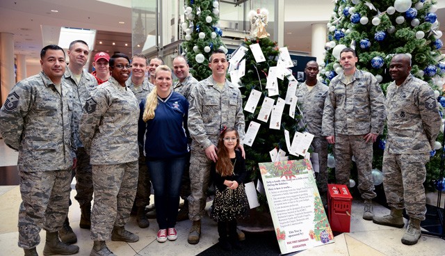 Caylee Lewis poses with her father, Master Sgt. Allen Lewis, 450th Intelligence Squadron first sergeant and Angel Tree 2015 chair, and other members of the Kaiserslautern Military Community First Sergeant Council during the Angel Tree 2015 kickoff Dec. 7 on Ramstein. Angel Tree is an outreach program designed to provide assistance to Airmen and their families throughout the KMC.
