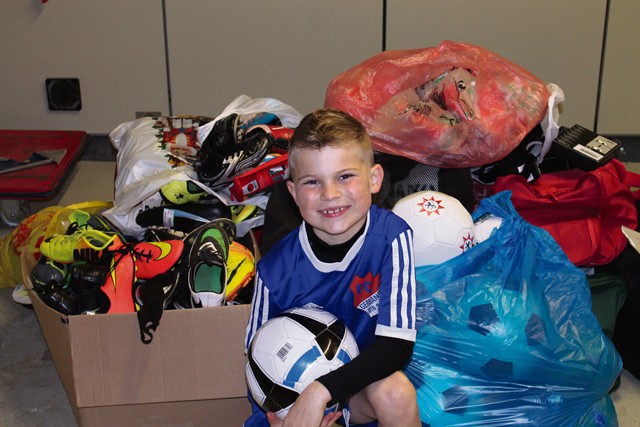 Courtesy photo Brayden Tester, son of Chief Master Sgt. David Tester, U.S. Air Forces in Europe operations superintendent, poses in front of soccer equipment on Ramstein. Brayden gathered support from around the KMC to collect soccer equipment for Ethiopian children that his father told him “couldn’t afford shoes to play in or soccer balls to play with.”