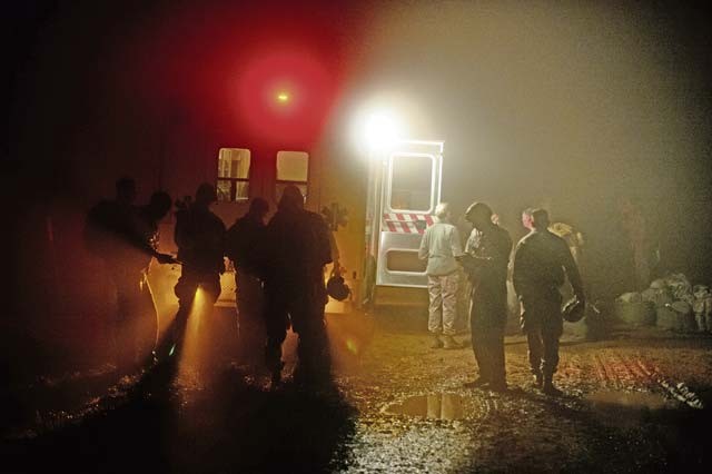 Members of the 435th Air Ground Operations Wing gather near an ambulance during a nighttime training jump Dec. 18 at Alzey Drop Zone, Germany. Medics from the 435th AGOW waited for their fellow Airmen, who dropped with paratroopers, in case of an emergency.