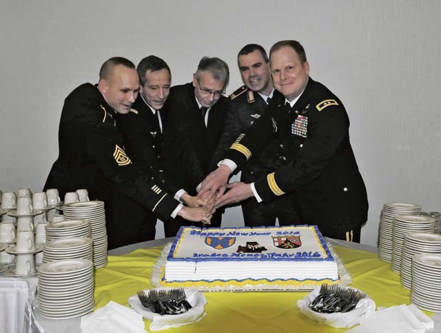 Photo by Greg Jones Command Sgt. Maj. Rodney Rhoades, 21st Theater Sustainment Command’s senior enlisted leader (left); French Army Lt. Gen. Dominque De Longvilliers, deputy commander of NATO’s Allied Air Command; Dr. Klaus Weichel, lord mayor of Kaiserslautern; Bundeswehr Brig. Gen Gerald Funke of the German Army Logistics Command; and Maj. Gen. Duane Gamble, the 21st TSC commanding general, cut the New Year’s cake with a military saber during the 2016 21st TSC New Year’s Reception Jan. 8 on Vogelweh.