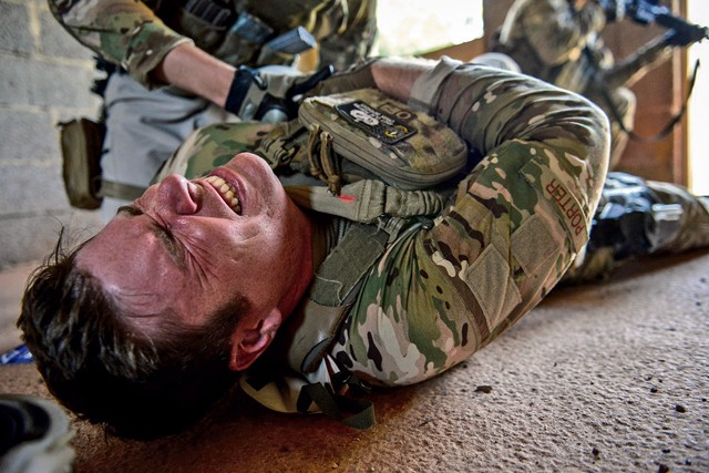 Photo by Senior Airman Nicole Sikorski Staff Sgt. Clay Porter, 435th Security Forces Squadron Ground Combat Regional Training Center instructor, is treated for a simulated gunshot wound during the Tactical Combat Casualty Care course Aug. 5, 2015, in Baumholder. Students learned how to gain fire superiority and treat uncontrolled bleeding with a tourniquet before continuing tactical field care during their medical training.