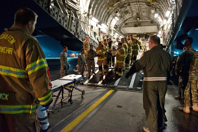 Photo by Staff Sgt. Leslie Keopka Firefighters and medical personnel transport a wounded warrior from a C-17 Globemaster III to an ambulance Aug. 9, 2015, on Ramstein. Personnel from the 86th Civil Engineer Squadron Kaiserslautern Military Community Fire Emergency Services, the 10th Aeromedical Evacuation Operations Team and the 455th Critical Care Air Transport Team assisted with the aeromedical evacuation out of Afghanistan.