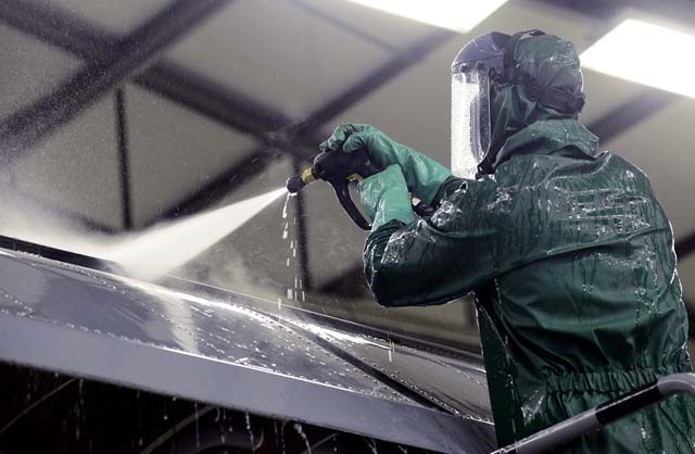 Airman Drew Thurau, 86th Maintenance Squadron crew chief, sprays water on the wing of a Ramstein C-130J Super Hercules during a pre-isochronal inspection wash Jan. 4 on Ramstein. An ISO inspection is a scheduled, extensive examination of an aircraft to maintain its functionality and perform preventive maintenance.