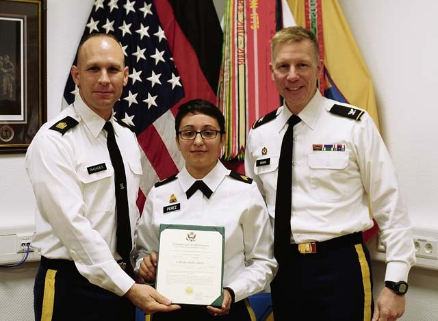 Sgt. Angelica Perez, Headquarters and Headquarters Company, 21st Theater Sustainment Command truck driver and administrative assistant, was promoted from specialist to sergeant Nov. 3 on Panzer Kaserne. Command Sgt. Maj. Rodney Rhoades, 21st TSC senior enlisted advisor (left), and Col. Dave Brown, 21st TSC deputy commanding officer, present Perez with her promotion.